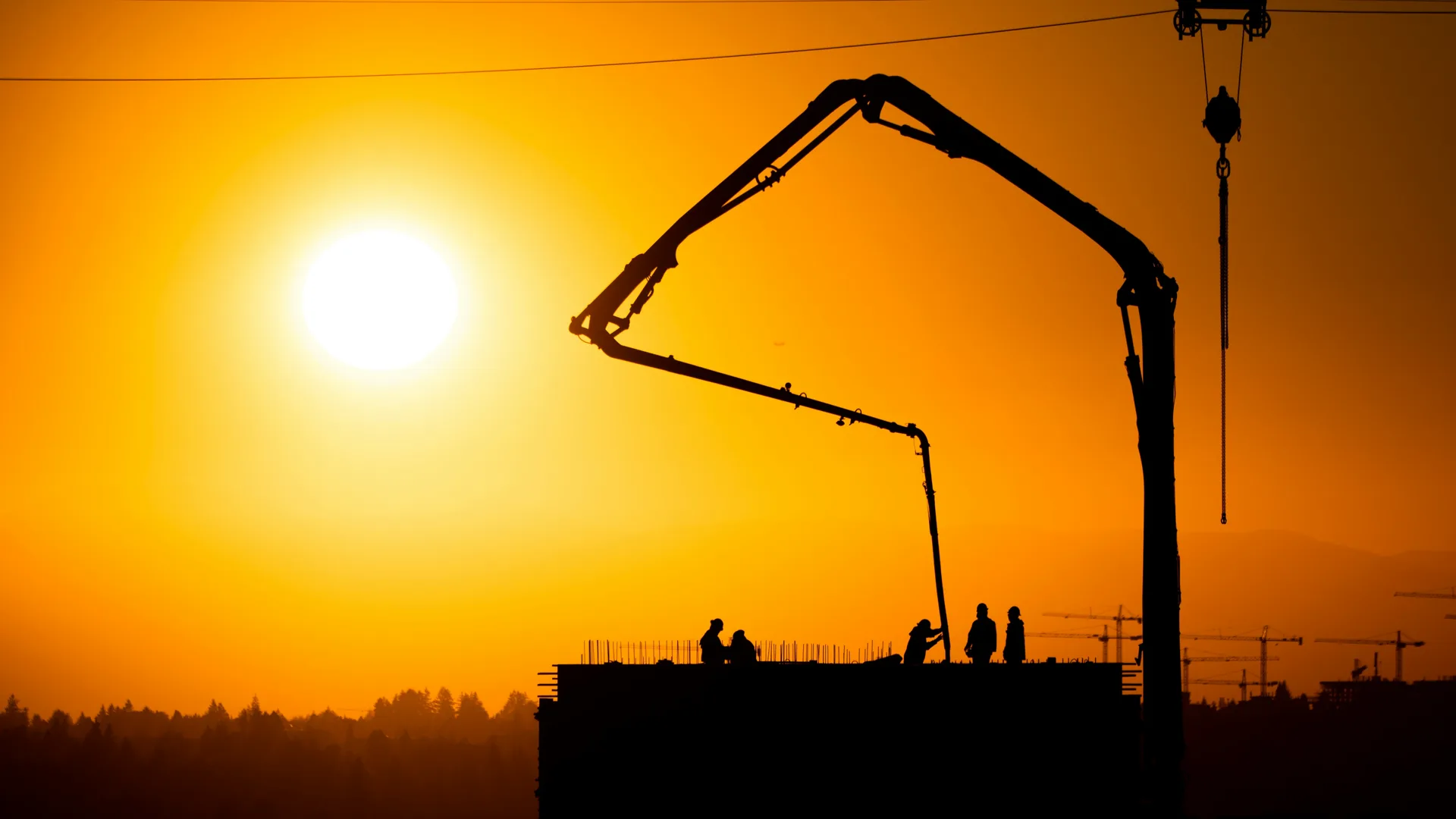 concrete boom pump on a Gatineau construction site at sunset