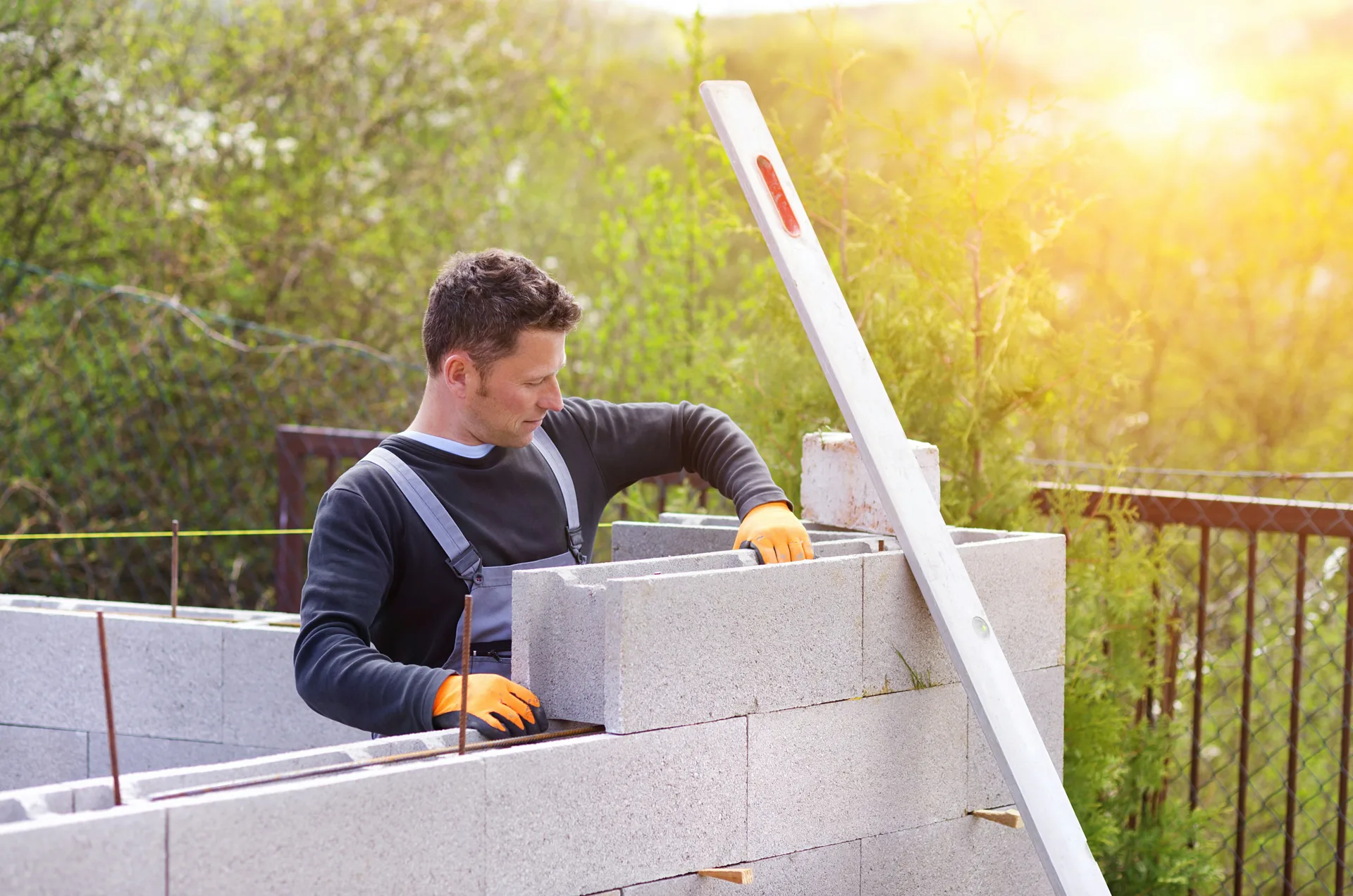 mason levelling a block retaining wall at a Gatineau property